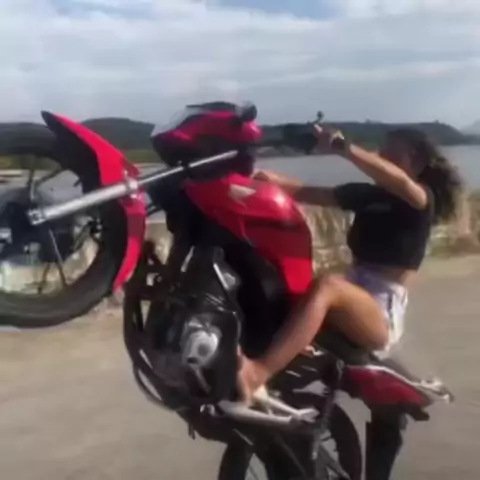 mulher dando um grau na moto 160